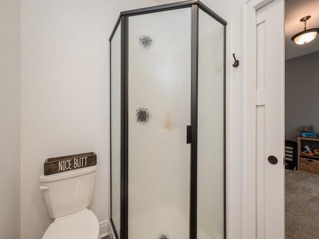 bathroom featuring a stall shower and toilet