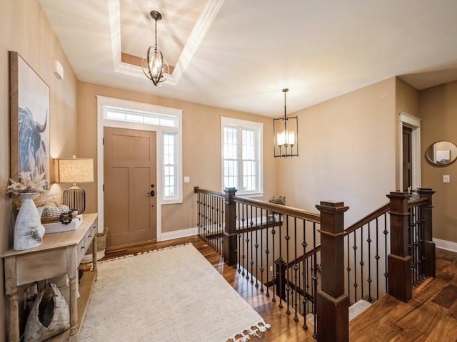 foyer entrance featuring a chandelier, wood finished floors, and baseboards
