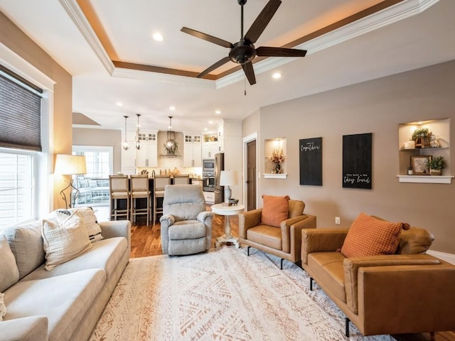 living area featuring a raised ceiling, crown molding, ceiling fan, wood finished floors, and recessed lighting