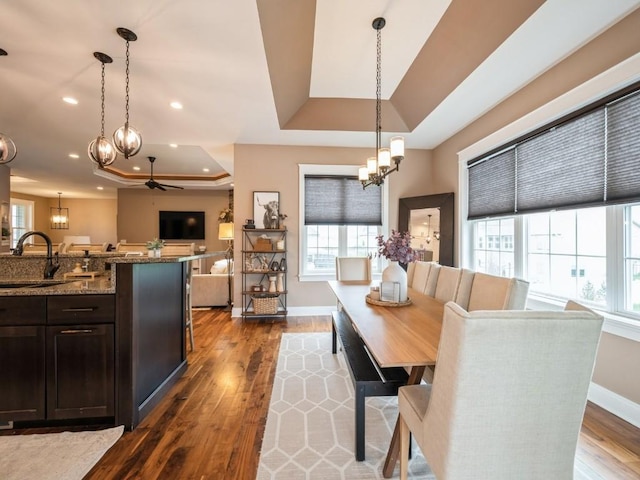 dining area with a chandelier, a tray ceiling, a ceiling fan, plenty of natural light, and recessed lighting