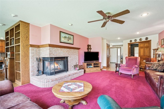 carpeted living area featuring a ceiling fan, a fireplace, recessed lighting, and a textured ceiling
