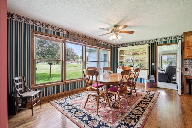4030 Bruce Rd, Marion, IA 52302 - dining room with wallpapered walls, a textured ceiling, ceiling fan, and wood finished floors