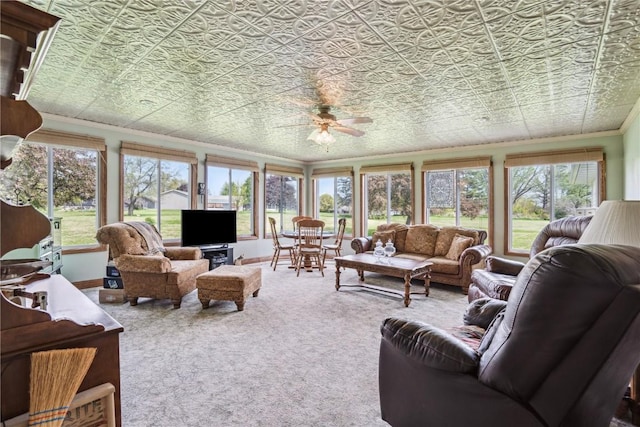 carpeted living room with crown molding, an ornate ceiling, ceiling fan, and plenty of natural light