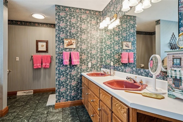 4030 Bruce Rd, Marion, IA 52302 - bathroom featuring baseboards, double vanity, wallpapered walls, and a chandelier