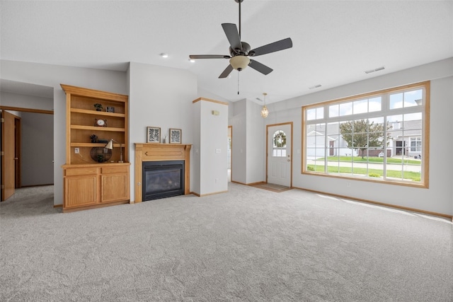 unfurnished living room with a glass covered fireplace, light colored carpet, vaulted ceiling, a ceiling fan, and baseboards