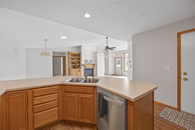 kitchen with stainless steel dishwasher, a sink, light wood-type flooring, light countertops, and vaulted ceiling