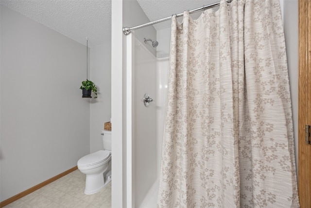 full bath with a textured ceiling, tile patterned floors, toilet, a shower with curtain, and baseboards