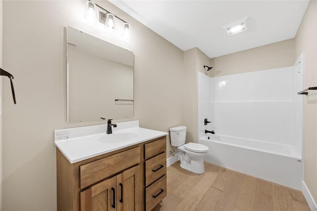 full bath with wood finished floors, toilet, vanity, washtub / shower combination, and baseboards