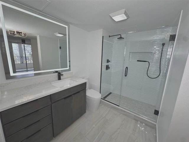 bathroom featuring toilet, a stall shower, vanity, and marble finish flooring