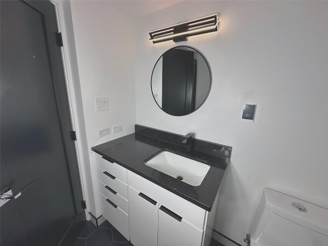 half bathroom featuring vanity, toilet, and tile patterned flooring