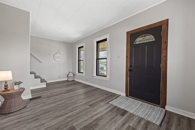 entryway with wood finished floors, stairs, baseboards, and ornamental molding