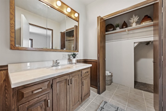 bathroom with a wainscoted wall, vanity, and tile patterned floors