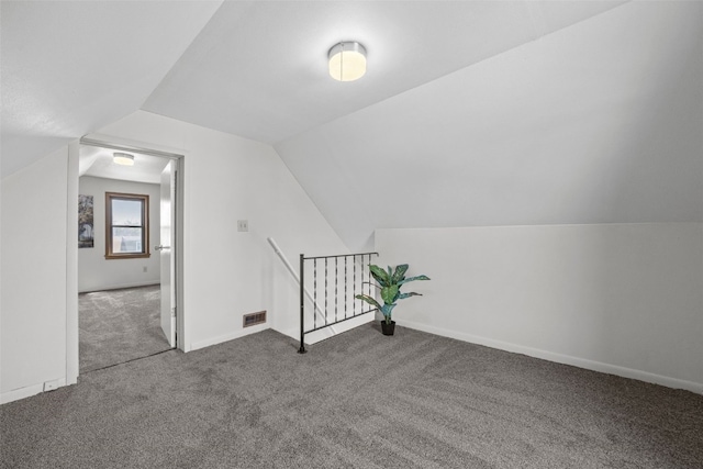 additional living space featuring carpet floors, vaulted ceiling, and baseboards