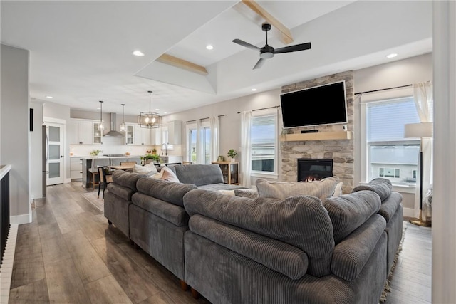 living area with a fireplace, a ceiling fan, wood finished floors, recessed lighting, and a chandelier