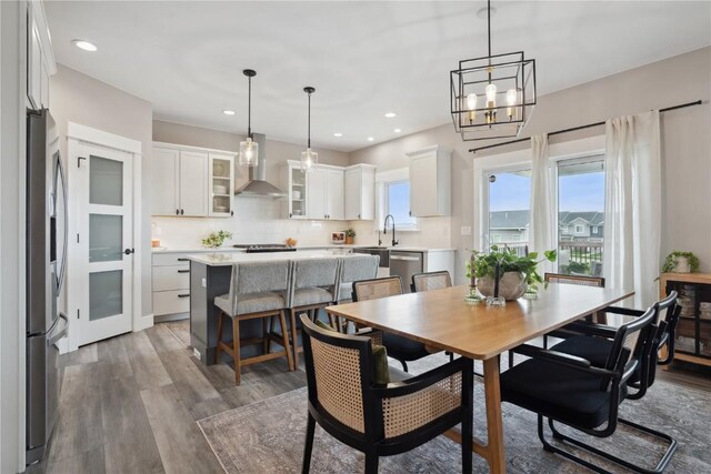 dining space featuring plenty of natural light, wood finished floors, recessed lighting, and a chandelier