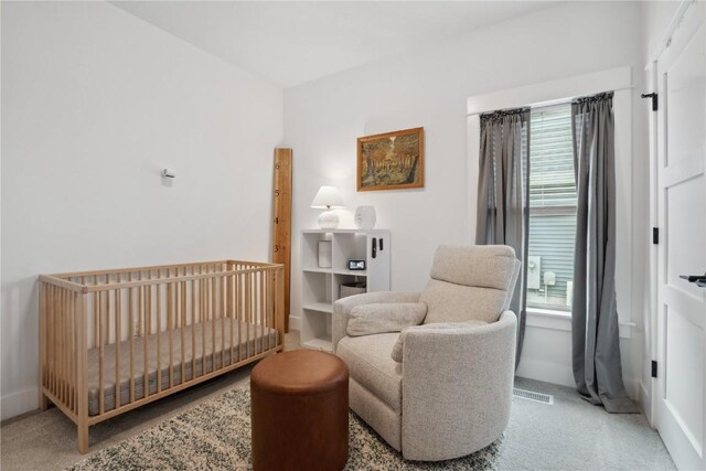 carpeted bedroom featuring multiple windows, a nursery area, and baseboards