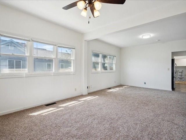 carpeted empty room with ceiling fan and baseboards