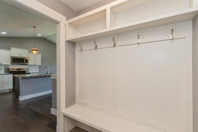 mudroom with dark wood-type flooring, vaulted ceiling, a sink, and recessed lighting