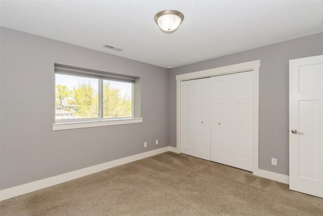 unfurnished bedroom featuring carpet flooring, baseboards, and a closet