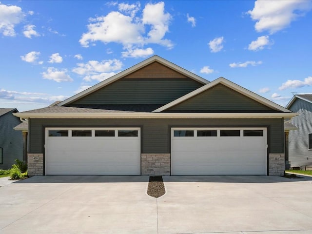 craftsman inspired home with stone siding and driveway