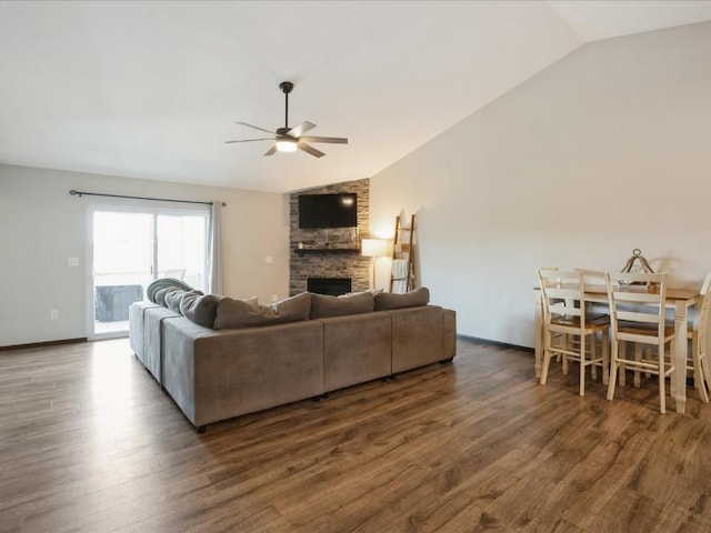 living room with lofted ceiling, a ceiling fan, a large fireplace, dark wood-type flooring, and baseboards