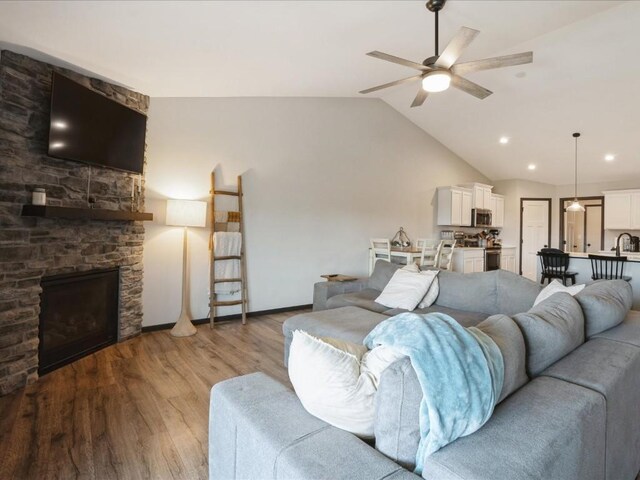 420 Dawson Dr, West Branch, IA 52358 - living area with wood finished floors, ceiling fan, a stone fireplace, vaulted ceiling, and recessed lighting