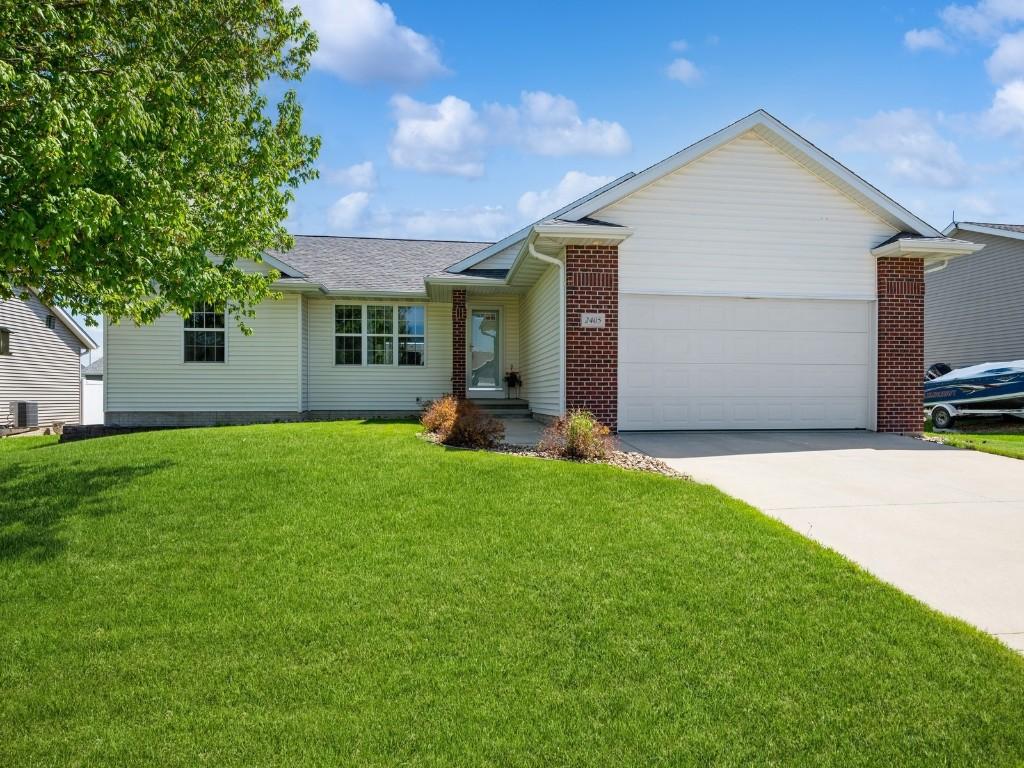 2405 Tamerac Dr, Marion, IA 52302 - ranch-style house with concrete driveway, an attached garage, a front yard, roof with shingles, and brick siding