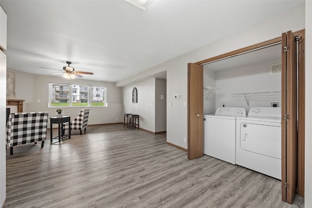 4619 1st Ave SW Unit 3, Cedar Rapids, IA 52404 - laundry room featuring washer and dryer, a ceiling fan, light wood-style floors, and baseboards