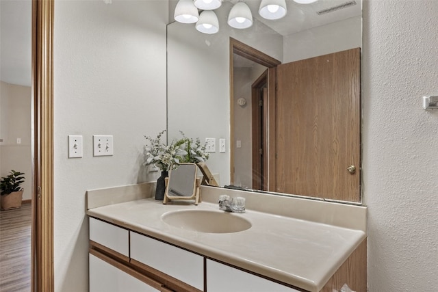 bathroom with vanity and a textured wall