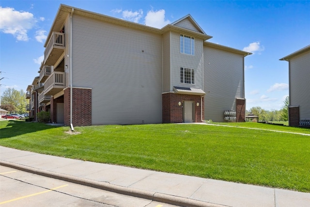250 Cimarron Dr Unit 207, Hiawatha, IA 52233 - rear view of property with brick siding and a yard