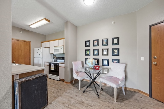 250 Cimarron Dr Unit 207, Hiawatha, IA 52233 - dining area with light wood-style floors, a textured ceiling, and baseboards