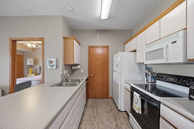 250 Cimarron Dr Unit 207, Hiawatha, IA 52233 - kitchen featuring white appliances, a sink, light wood-type flooring, a textured ceiling, and white cabinets