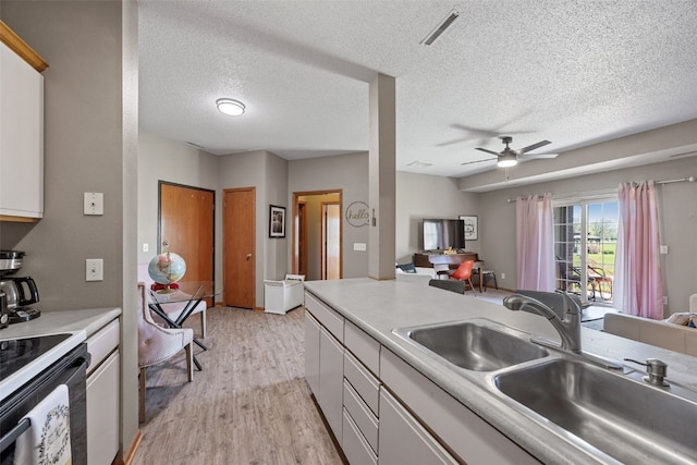 250 Cimarron Dr Unit 207, Hiawatha, IA 52233 - kitchen featuring a sink, range with electric stovetop, light wood-type flooring, a ceiling fan, and a textured ceiling