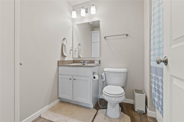 1227 Mary Ln, North Liberty, IA 52317 - bathroom featuring wood finished floors, toilet, vanity, baseboards, and a shower with curtain