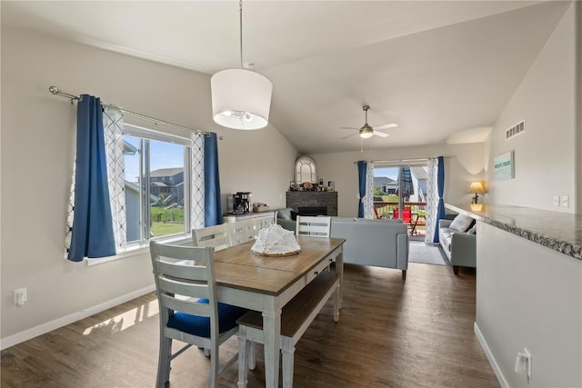 1227 Mary Ln, North Liberty, IA 52317 - dining area featuring lofted ceiling, wood finished floors, a ceiling fan, baseboards, and a fireplace