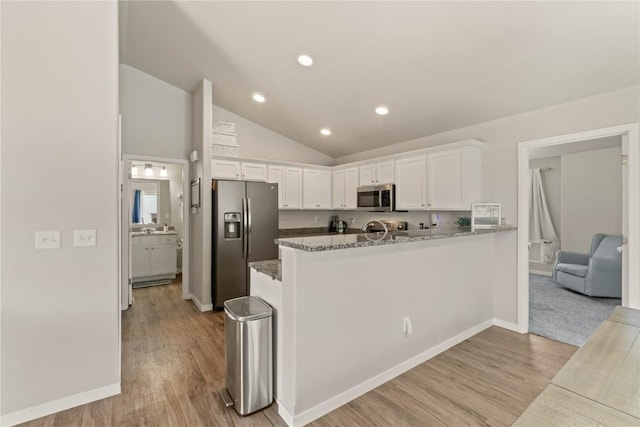 1227 Mary Ln, North Liberty, IA 52317 - kitchen with appliances with stainless steel finishes, white cabinets, stone counters, light wood-type flooring, and a peninsula