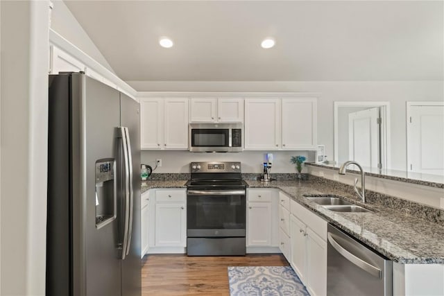 1227 Mary Ln, North Liberty, IA 52317 - kitchen featuring appliances with stainless steel finishes, a sink, white cabinets, lofted ceiling, and recessed lighting