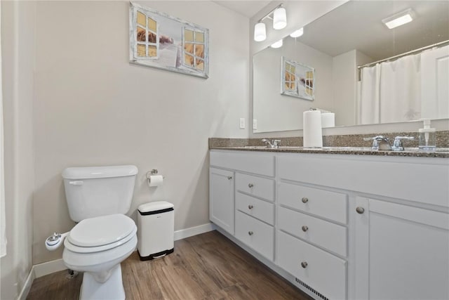1227 Mary Ln, North Liberty, IA 52317 - bathroom with baseboards, toilet, wood finished floors, and double vanity