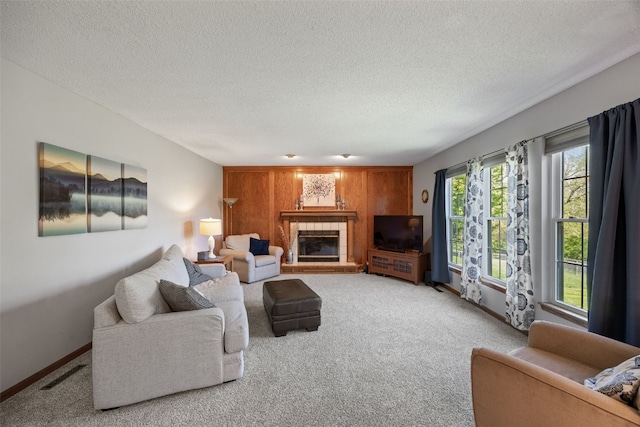 living area with carpet, a textured ceiling, a fireplace, and baseboards