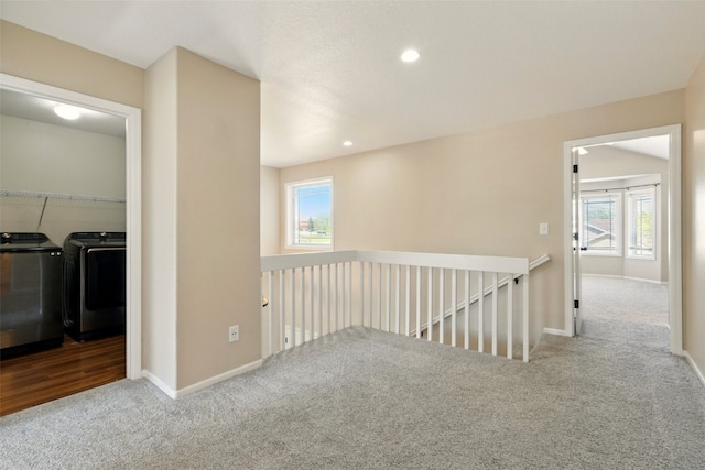 corridor with carpet flooring, washing machine and dryer, an upstairs landing, healthy amount of natural light, and recessed lighting