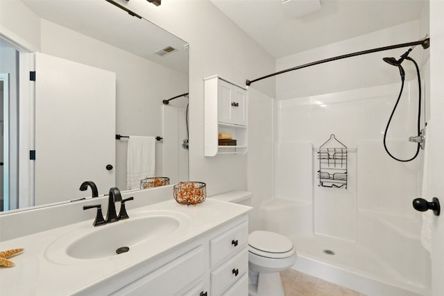bathroom featuring a shower, toilet, vanity, and tile patterned flooring