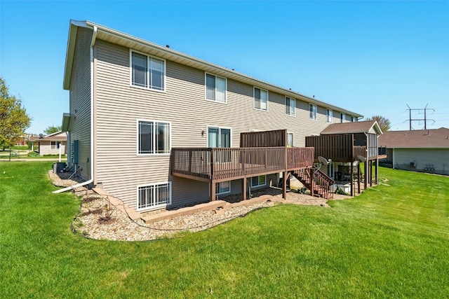 back of house with a deck, stairs, and a lawn