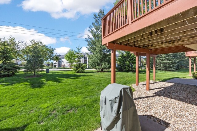 view of green lawn with a wooden deck