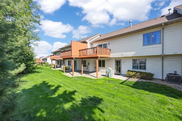 rear view of house featuring a lawn, central AC unit, and a deck