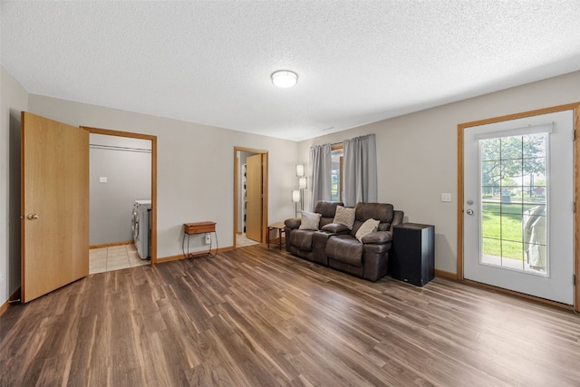 living room with wood finished floors, plenty of natural light, a textured ceiling, and baseboards