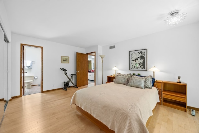 13 Woodland Hts, Iowa City, IA 52240 - bedroom with light wood finished floors, ensuite bath, and baseboards