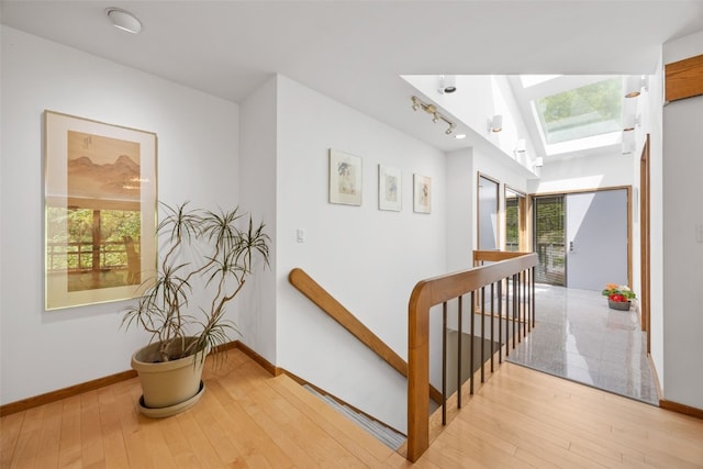 13 Woodland Hts, Iowa City, IA 52240 - hallway with an upstairs landing, a skylight, hardwood / wood-style flooring, and baseboards