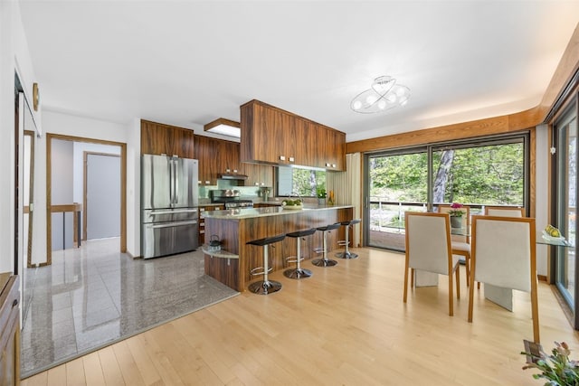13 Woodland Hts, Iowa City, IA 52240 - kitchen with stainless steel appliances, a kitchen breakfast bar, a peninsula, modern cabinets, and light wood-style flooring