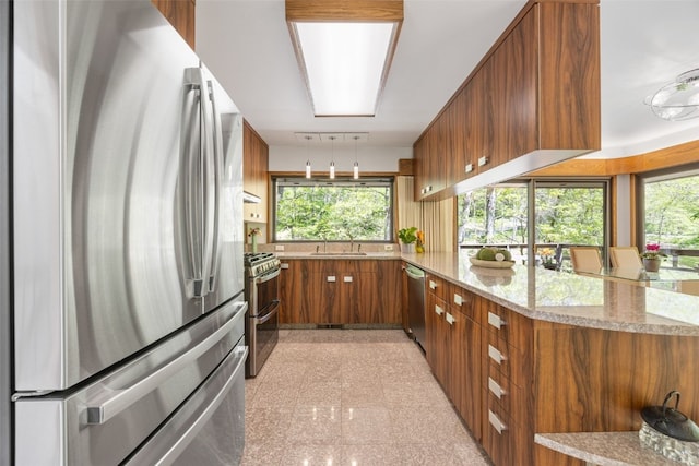 13 Woodland Hts, Iowa City, IA 52240 - kitchen featuring appliances with stainless steel finishes, brown cabinetry, granite floors, a sink, and light stone countertops