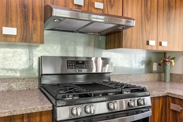 13 Woodland Hts, Iowa City, IA 52240 - kitchen featuring stainless steel range with gas cooktop, range hood, brown cabinetry, and backsplash